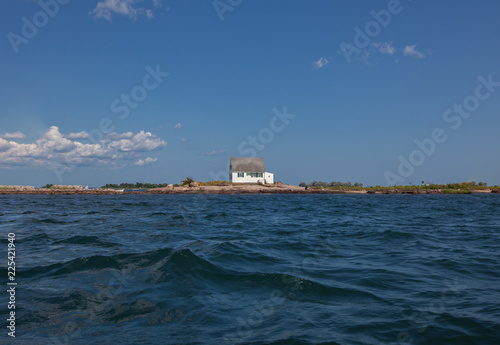 Landscape with house on coast seen from sea