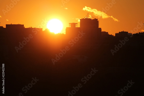 Cityscape with silhouette of city skyline against setting sun. Minsk  Belarus