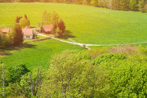 View from the drone on a country house with buildings. Summer nature near the German village. View from the height of the green forests, fields, meadows.