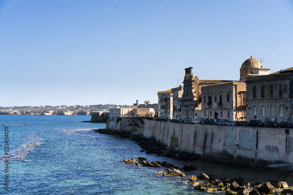 Ancient sea wall and buildings with distant views on Ortigia Island, Syracuse, Sicily
