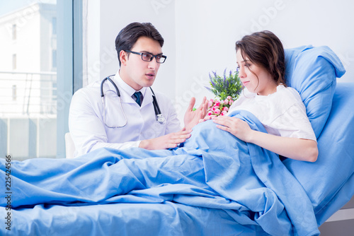 Doctor visiting pregnant in hospital room