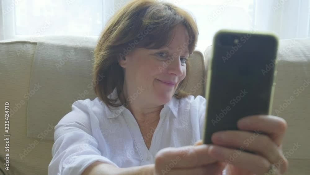 Senior caucasian woman taking selfies and making funny faces on her smartphone Senior caucasian woman taking selfies and making funny faces on her smartphone