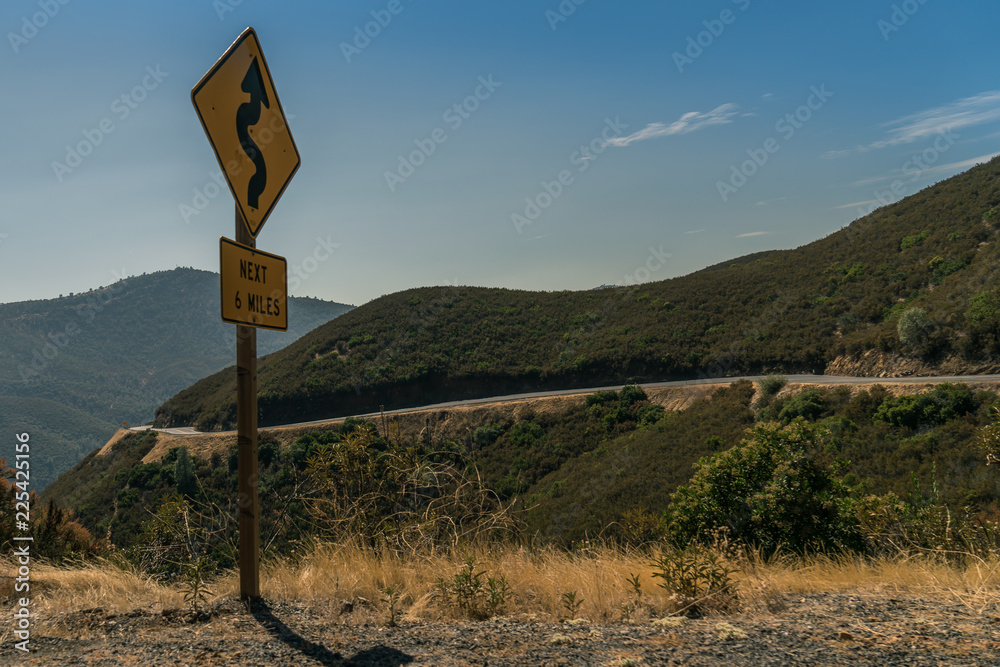 Curvy road sign on a beautiful road way Curvy road sign on a beautiful road way