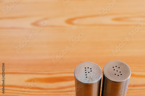 Salt shaker and pepper shaker on a wooden table, copyspace