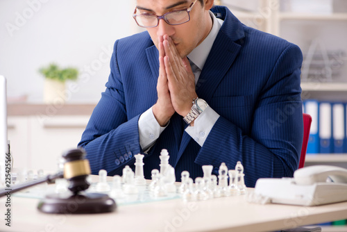 Young lawyer playing chess to train his court strategy and tacti photo