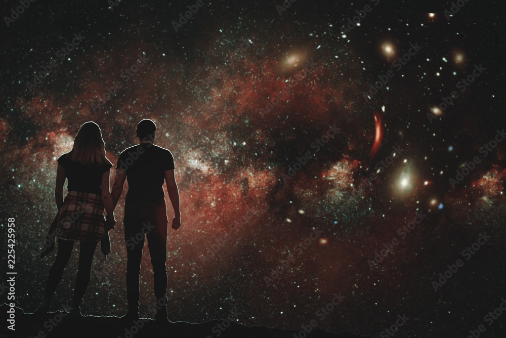 The silhouette of a lovers pair who looks at the night sky. A conceptual illustration of the silhouettes of people watching the cosmos. Boy and girl holding hands looking at the stars.