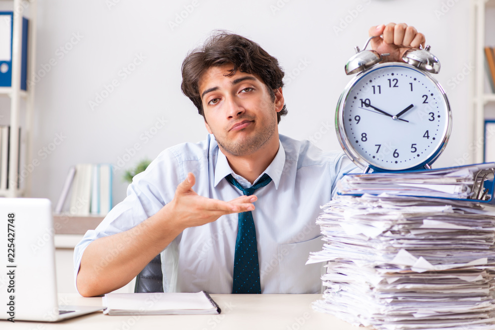 Overloaded busy employee with too much work and paperwork Overloaded busy employee with too much work and paperwork