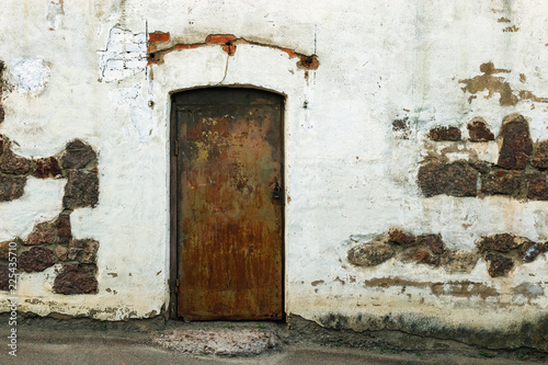 Shabby building facade with closed door. Old white wall. Historical Old building. © yrabota