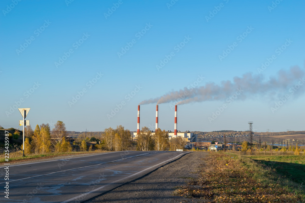 Autumn season, view of the pipes, plant and residential sector from the asphalt road