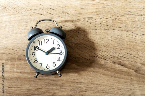 Alarm clock on a bright wooden background , time management concept