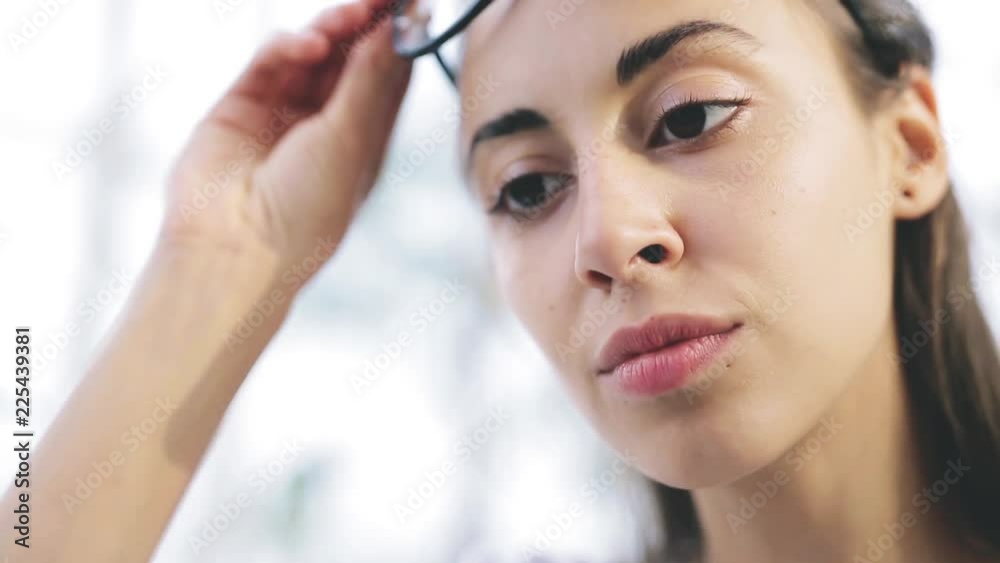 close up portrait of focused young beautiful businesswoman in glasses working on laptop in bright modern office. Business or freelance concept close up portrait of focused young beautiful businesswoman in glasses working on laptop in bright modern office. Business or freelance concept