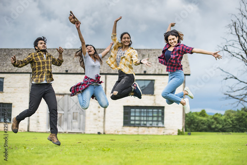 Student group Summer school excited;They are jumping, education, school and people concept - group of students in background at each other at school; Asia studen study.