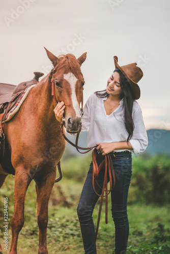 Asian young woman take care of her blows horse at sunset.