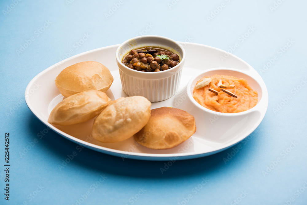 Suji/Sooji Halwa Puri or Shira Poori with black chana masala breakfast, served in a plate and bowl. selective focus Suji/Sooji Halwa Puri or Shira Poori with black chana masala breakfast, served in a plate and bowl. selective focus