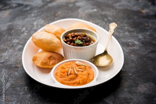 Suji Sooji Halwa Puri or Shira Poori with black chana masala breakfast  served in a plate and bowl. selective focus