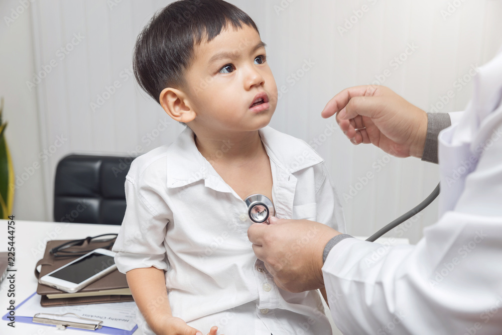 Pediatrician doctor examining a little asian boy by stethoscope Pediatrician doctor examining a little asian boy by stethoscope