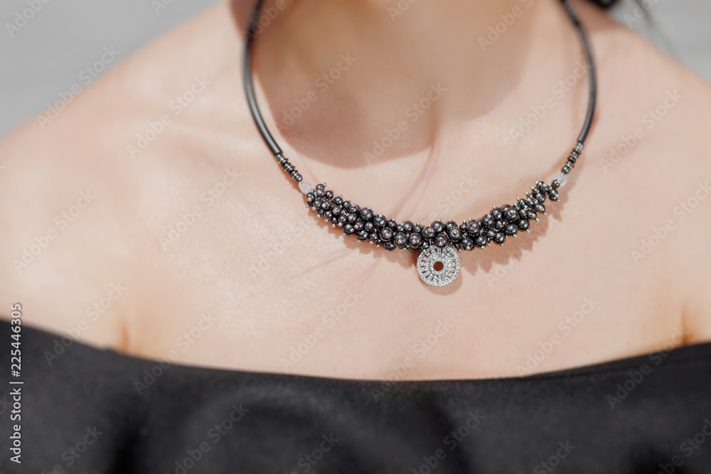 close-up portrait of a beautiful woman wearing stylish handmade jewelry necklace. Fashion accessories concept