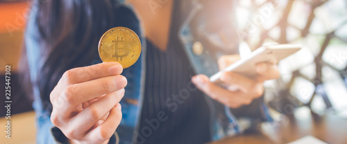 Obraz na płótnie The hand of a woman holding a currency, bitcoin. w salonie