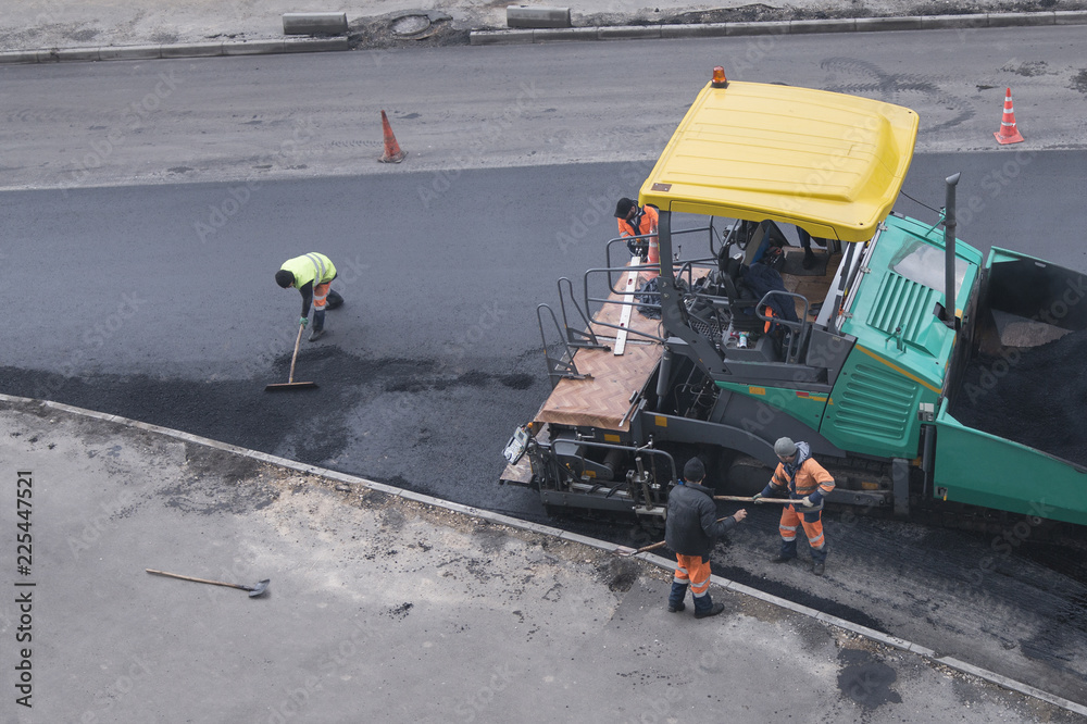 Asphalt paver machine or paver finisher and road construction workers ...