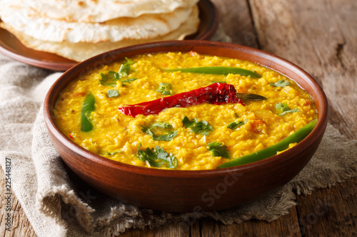 Delicious Dal Tadka recipe of yellow lentils with spices, herbs and chili pepper close-up in a bowl. horizontal