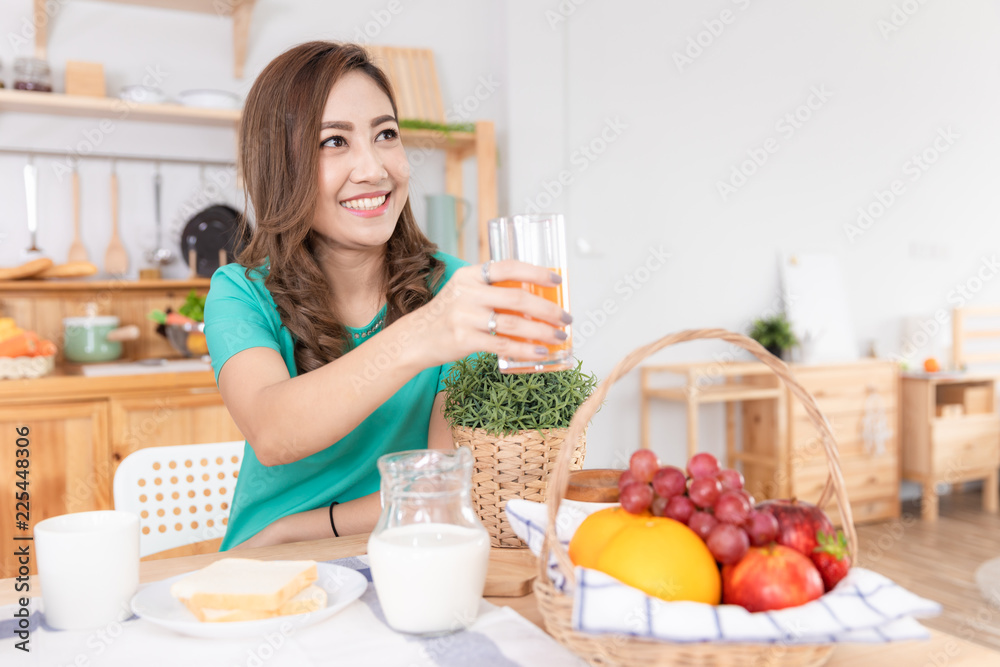 mother holding hand orange juice drinking breakfast in the kitchen on the wood table mother holding hand orange juice drinking breakfast in the kitchen on the wood table