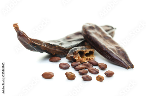 Carob on white background. Organic carob pods with seeds photo