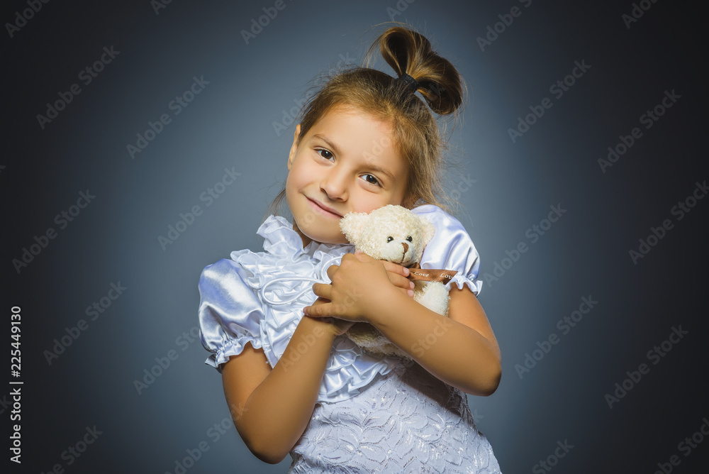 portrait of happy girl playing with teddy bear isolated on gray portrait of happy girl playing with teddy bear isolated on gray