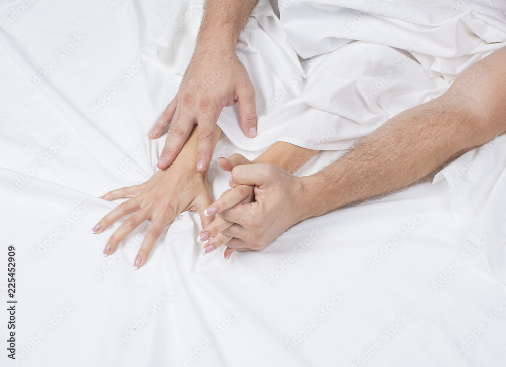 Close up of passionate couple hold hands during making intense love in bedroom, lovers enjoy pic