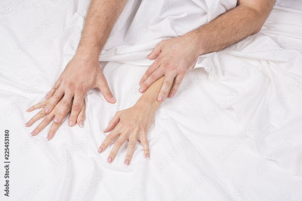 Close up of passionate couple hold hands during making intense love in bedroom, lovers enjoy pic