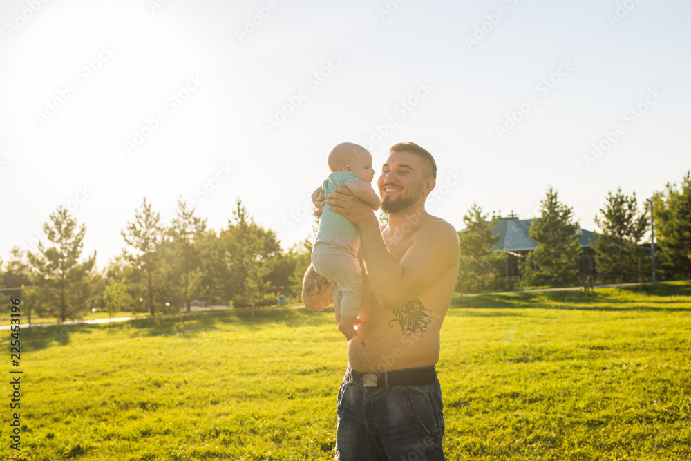 Happy father holding baby son, throwing baby in air. Concept of happy family, father's day and child.