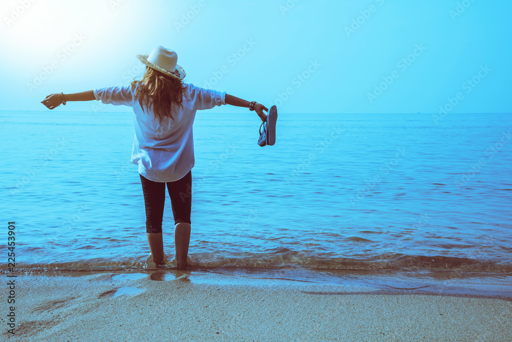 Asian woman travel nature. Travel relax. Walking on the beach. In the summer