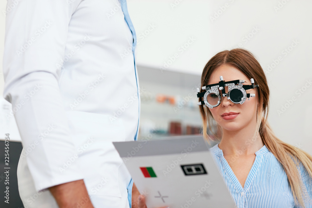 Fototapeta Badanie wzroku. Kobieta w okularach optometrii, czytanie karty testowej oka