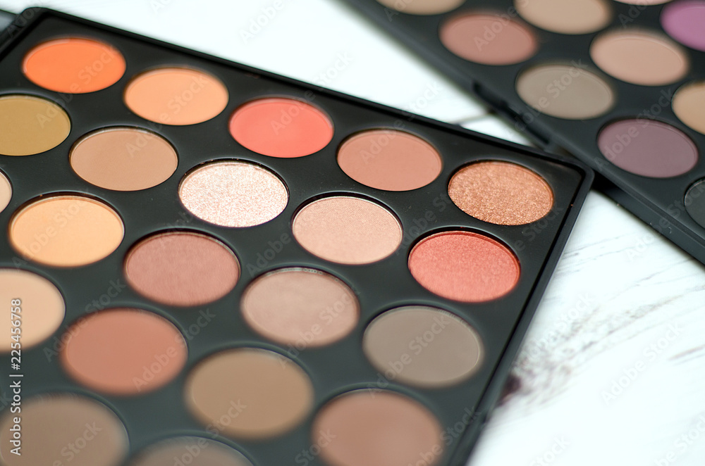 natural cosmetics, a palette of multi-colored eye shadows on a light wooden background natural cosmetics, a palette of multi-colored eye shadows on a light wooden background