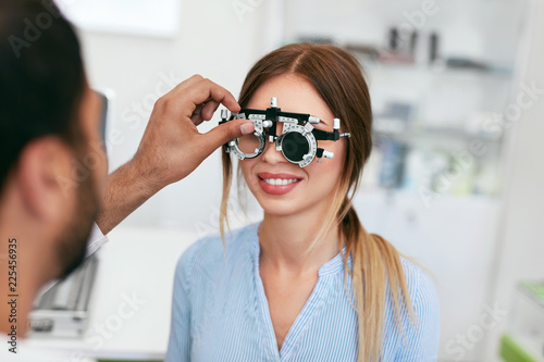 Optometry Test. Eye Doctor Checking Woman Eyesight At Clinic photo