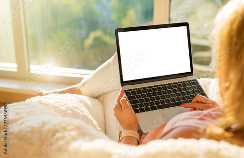 Woman using laptop computer with blank white screen photo