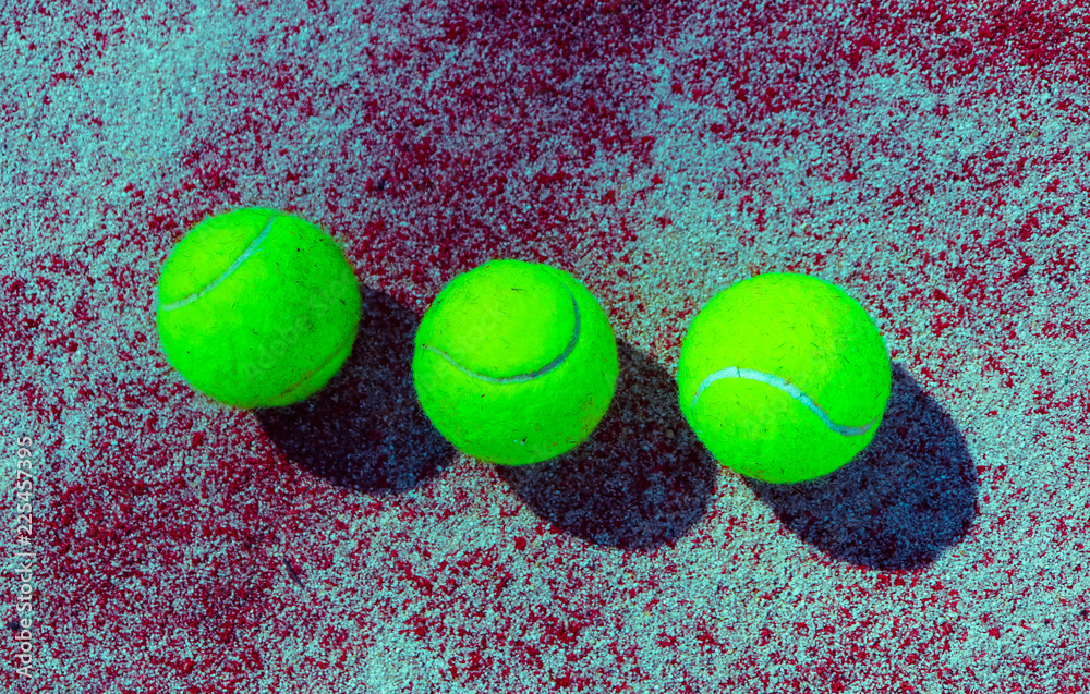 Three green tennis balls on the sunny court, sport competition concept. Tennis backdrop, close up.