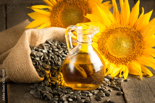 Closeup photo of sunflower oil with seeds on wooden background. Bio and organic product concept. photo