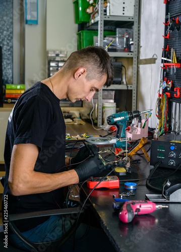 Professional repairman repairing computer in workshop