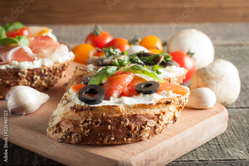 Italian tomato and cheese bruschetta. Tapas, antipasti with chopped vegetables, herbs and oil on grilled ciabatta and baguette bread.