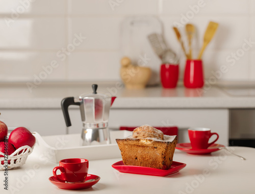 Interior white kitchen with kitchen tools and red crockery.