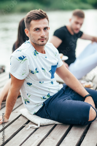 Handsome young man relaxing on wooden pier
