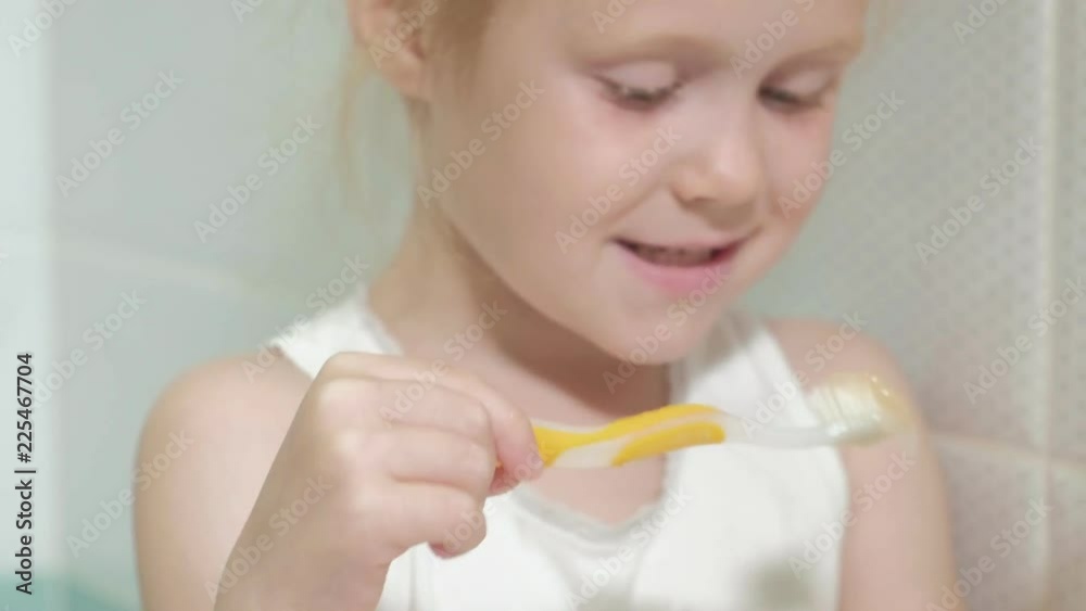 Little girl diligently brushing his teeth in the mirror. Little girl diligently brushing his teeth in the mirror.