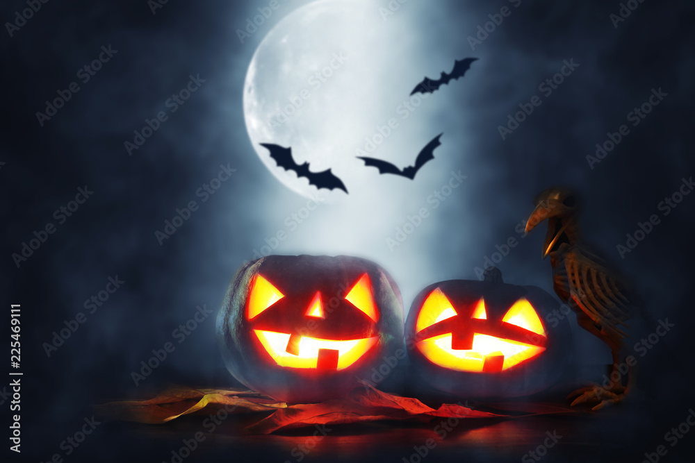 Halloween holiday concept. Pumpkins over wooden table at night scary, haunted and misty forest. Halloween holiday concept. Pumpkins over wooden table at night scary, haunted and misty forest.