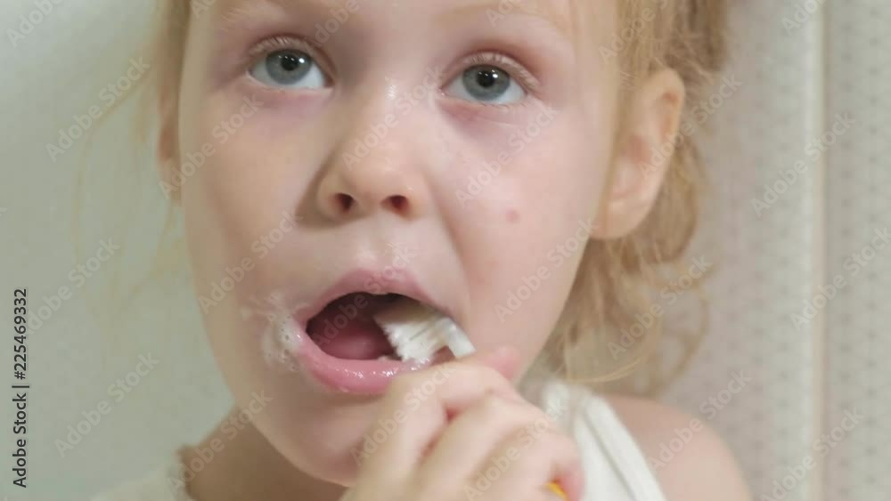 Little girl diligently brushing his teeth in the mirror. Little girl diligently brushing his teeth in the mirror.