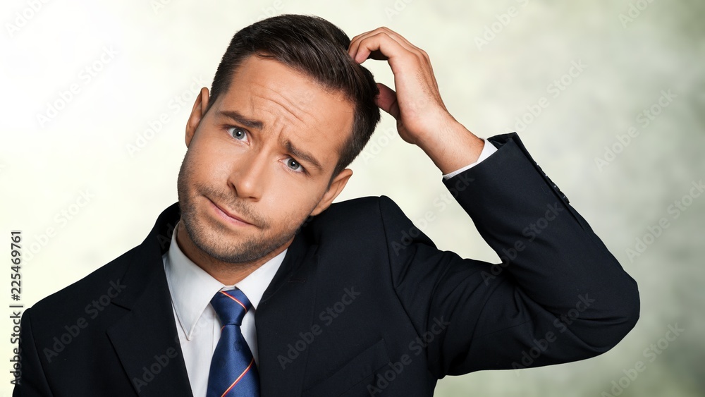 Young businessman scratching his head, hard decision Young businessman scratching his head, hard decision