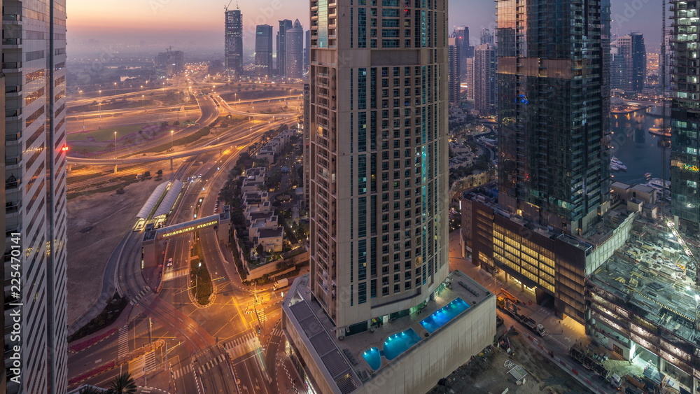 Fototapeta premium Aerial view of a road intersection in a big city night to day timelapse.