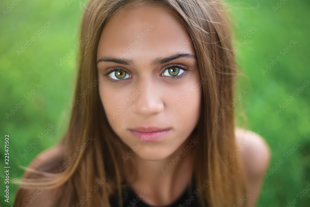 Beautiful young woman close-up in black shirt, against green of summer park.
Ecology concept Beautiful young woman close-up in black shirt, against green of summer park.
Ecology concept