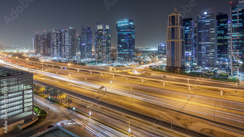 Aerial view of Jumeirah lakes towers skyscrapers night timelapse with traffic on sheikh zayed road.