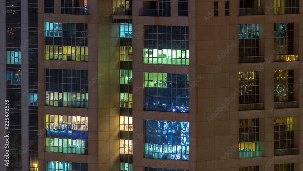 Windows of the multi-storey building of glass and steel lighting inside and moving people within timelapse Windows of the multi-storey building of glass and steel lighting inside and moving people within timelapse