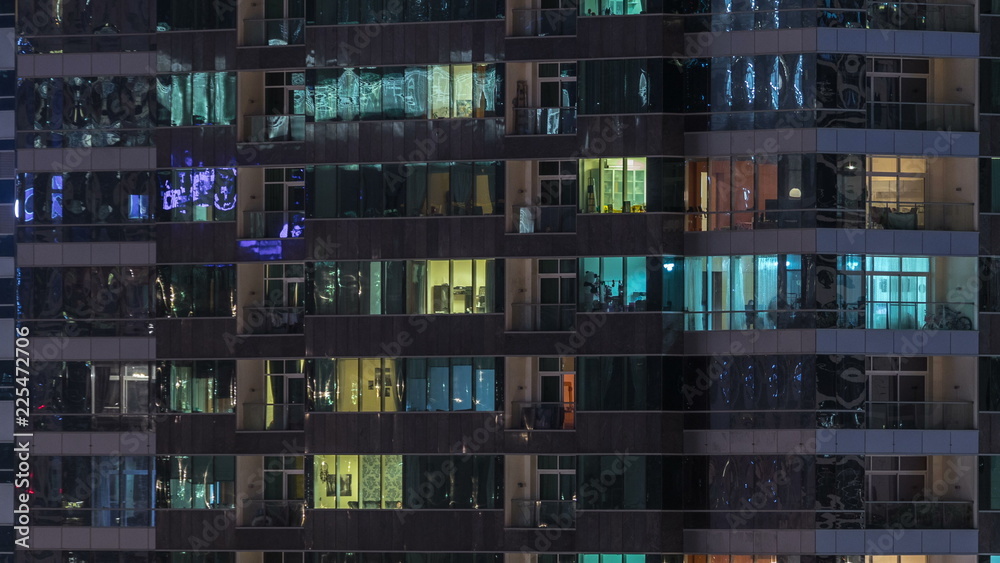 Windows of the multi-storey building of glass and steel lighting inside and moving people within timelapse - obrazy, fototapety, plakaty 